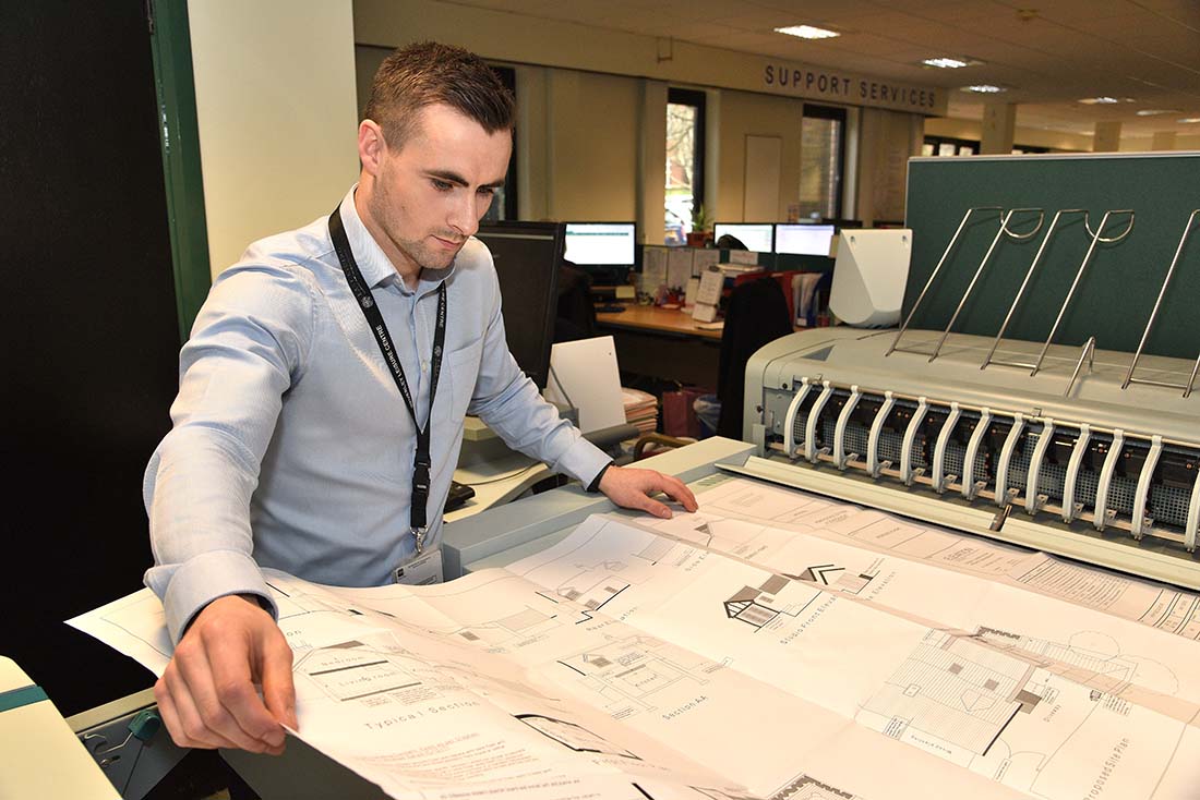 Building control officer printing drawing plans for use on site